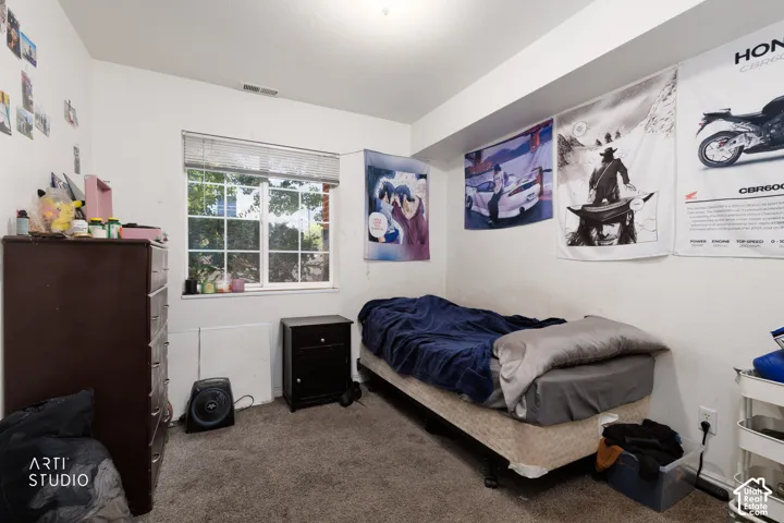Carpeted room with a window featuring blinds and a white frame