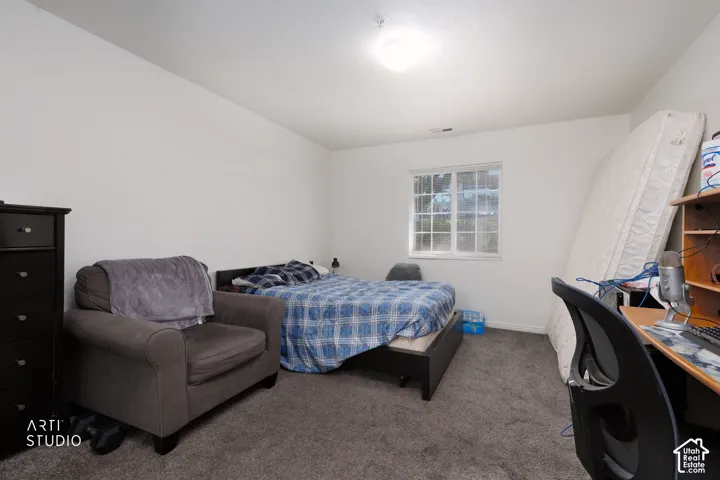 Carpeted room with a ceiling-mounted light fixture and a window