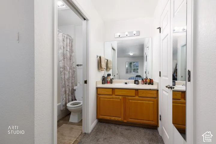 Vanity with wood-finish cabinetry, countertop, and large mirror