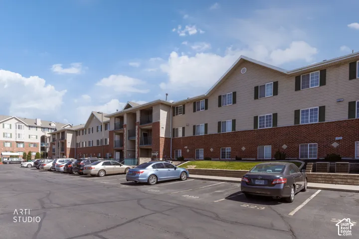 Multi-story building featuring brick and siding exterior, multiple windows with shutters, and private balconies