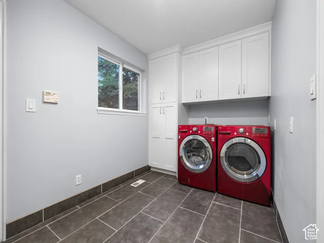 White shaker-style cabinetry with crown molding, durable tile flooring, and a single window
