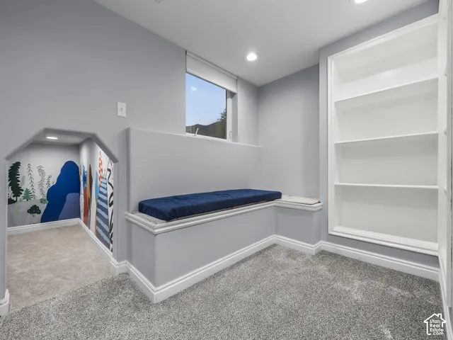 Built-in window bench, recessed lighting, built-in shelving, low-profile window, and grey wall color