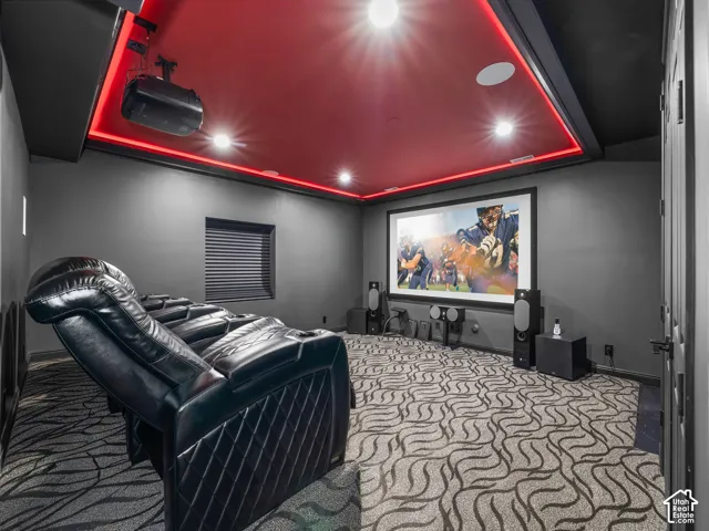 Dedicated media room featuring a large projection screen, built-in recessed lighting, and a red illuminated ceiling panel