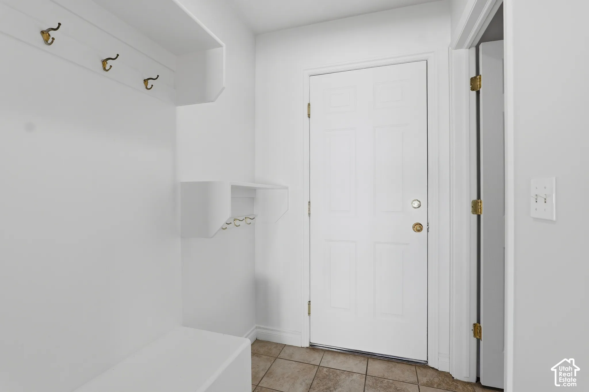 Built-in hall tree with storage bench, wall-mounted coat hooks, and durable tile flooring