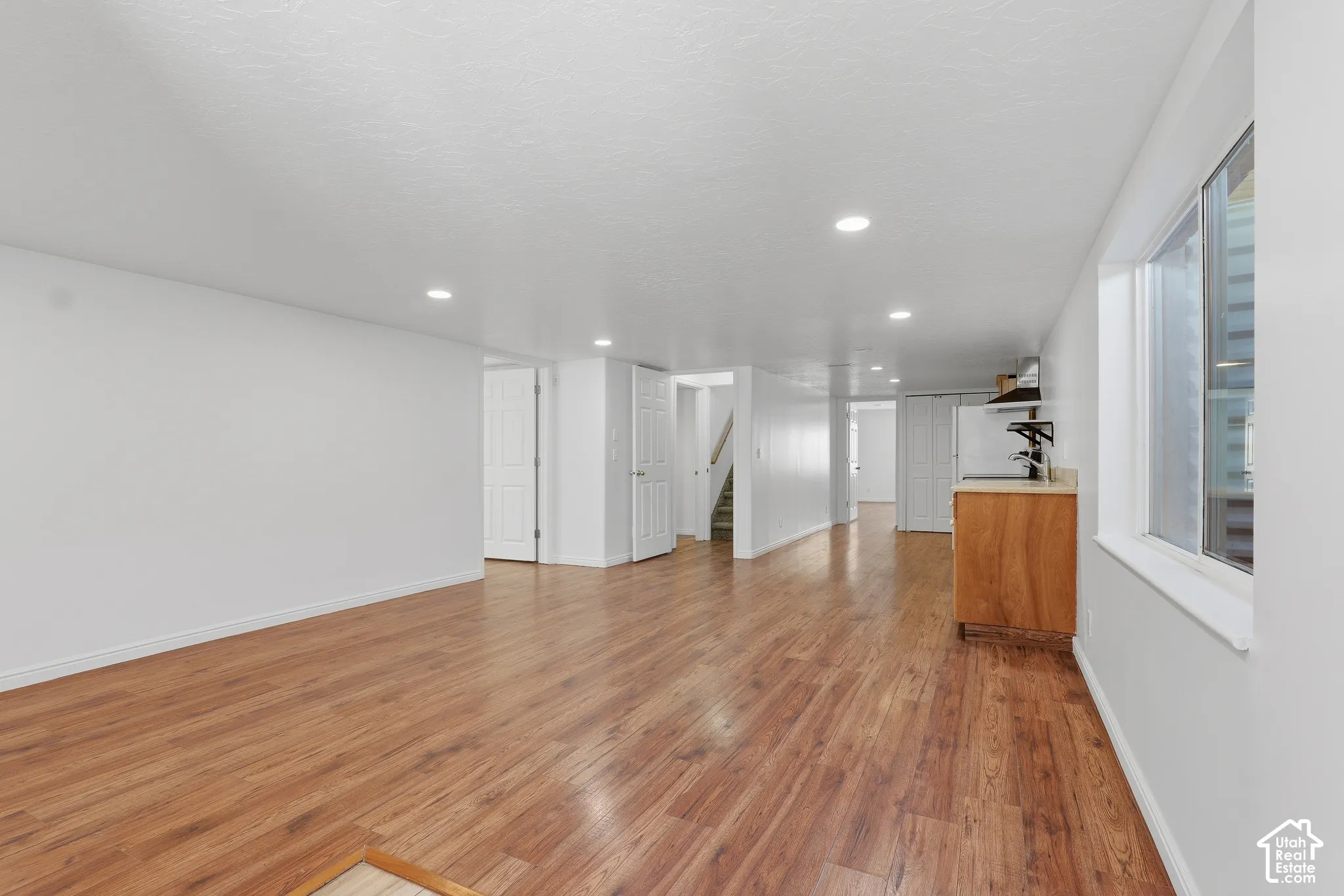 Spacious room featuring recessed lighting, white walls, and a window providing natural illumination