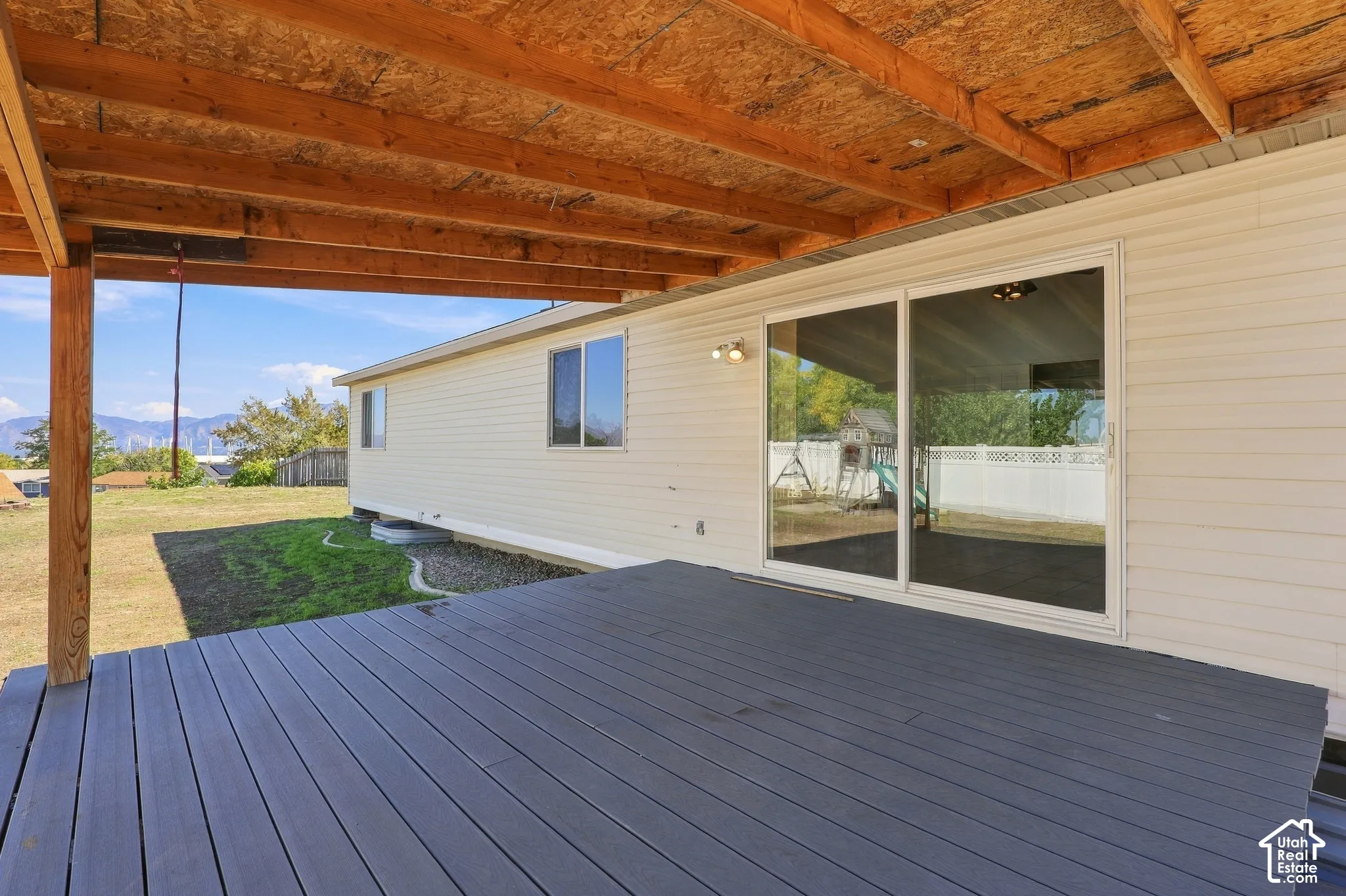 Covered deck with composite decking, sliding glass doors, and recessed lighting