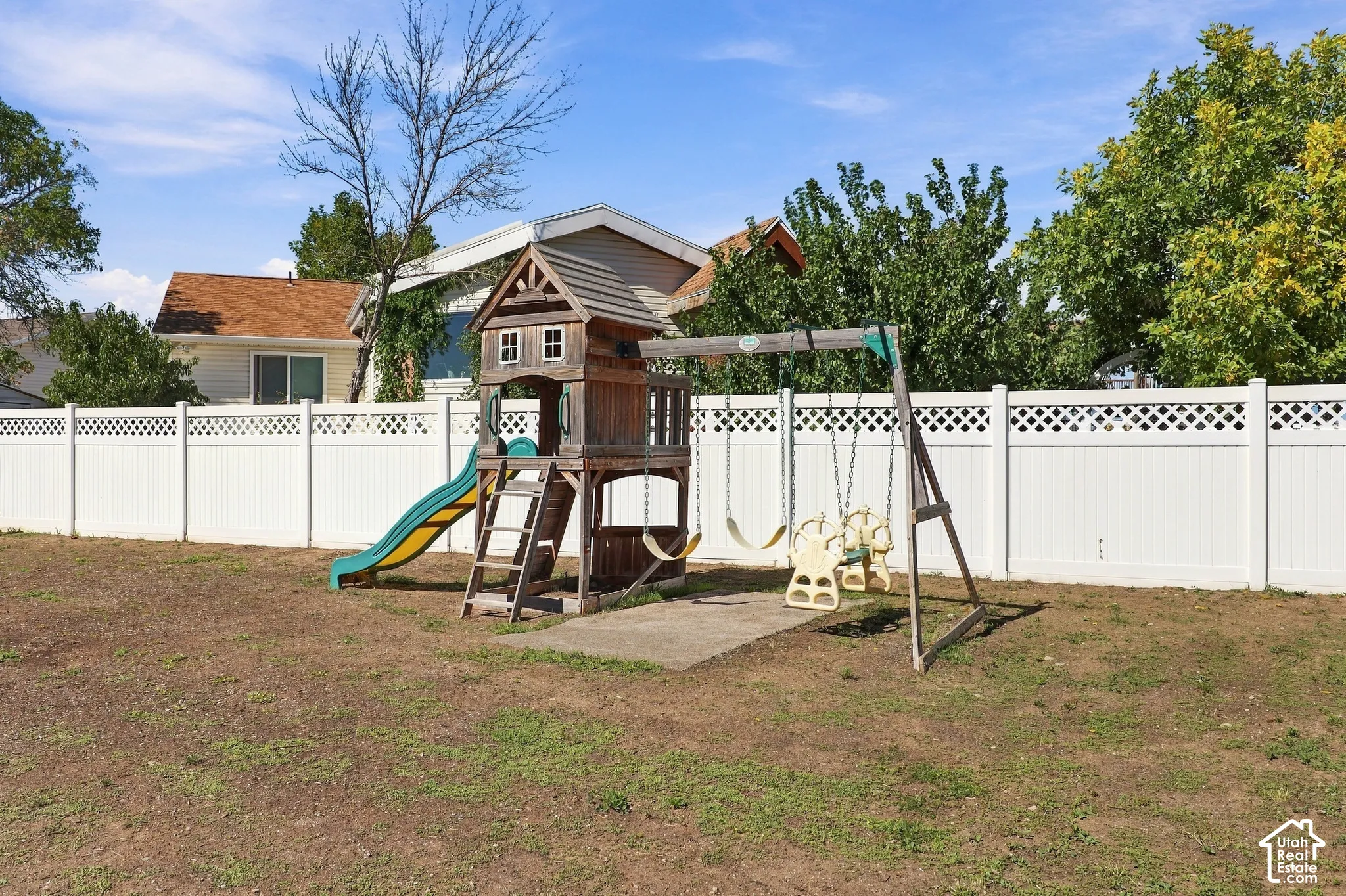 Expansive backyard featuring a white lattice-top fence