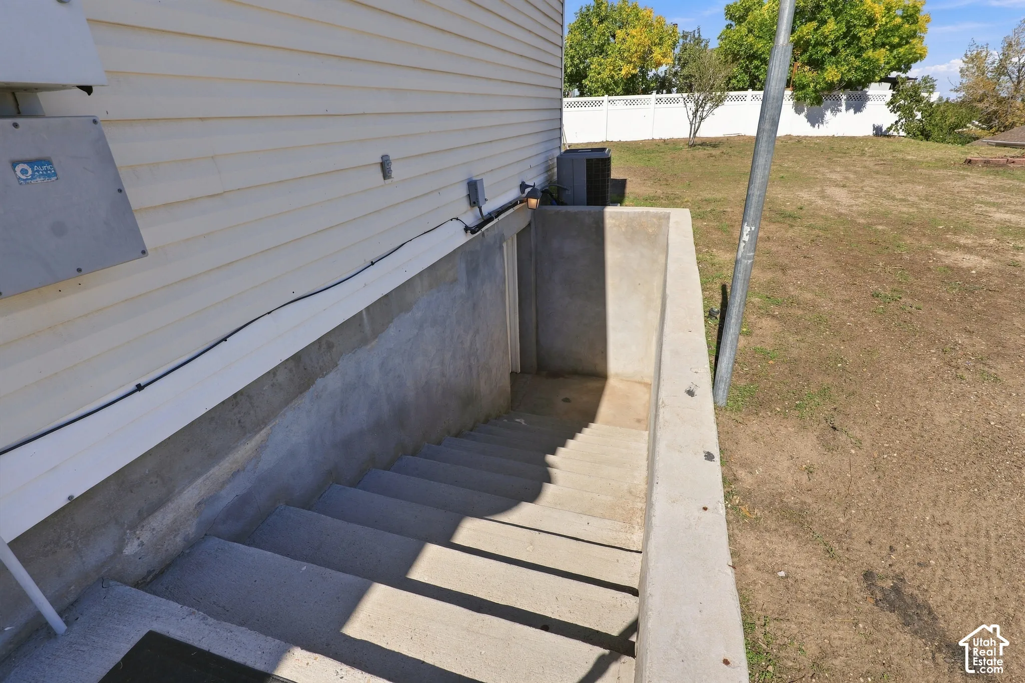 Concrete exterior basement entry with steps and siding
