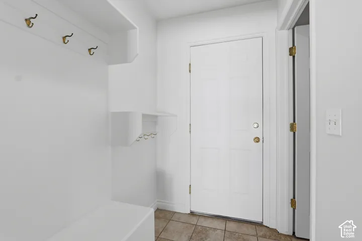 Built-in hall tree with storage bench, wall-mounted coat hooks, and durable tile flooring