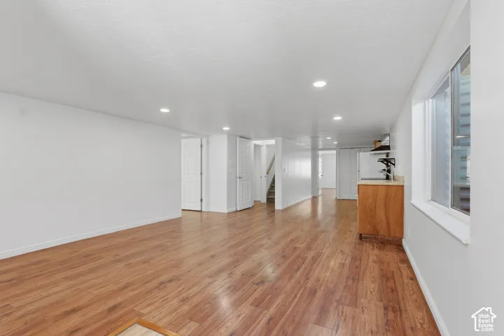Spacious room featuring recessed lighting, white walls, and a window providing natural illumination