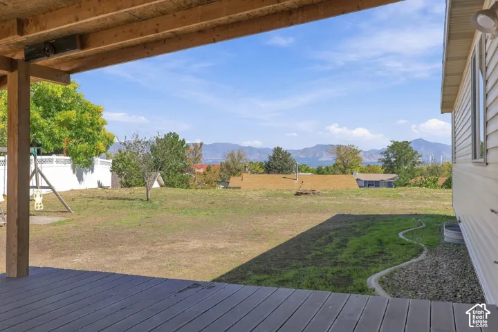 Expansive backyard featuring a deck, mountain view.