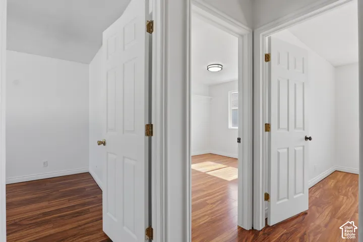 White paneled interior doors, wood-finish flooring, recessed window, and flush-mount ceiling light fixture