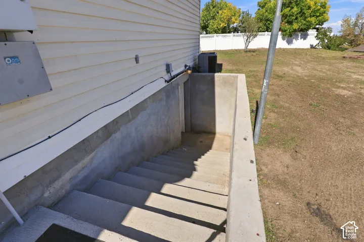 Concrete exterior basement entry with steps and siding
