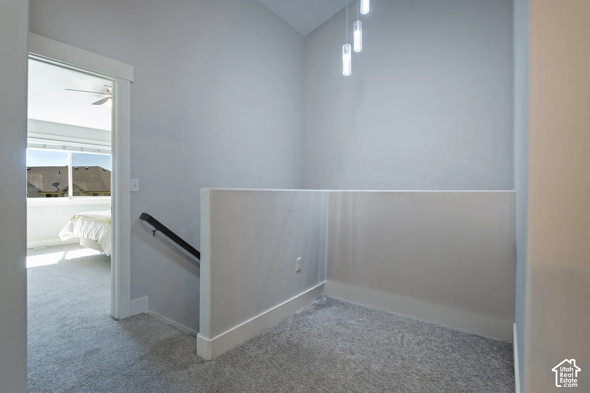 Recessed lighting fixtures, stairwell railing, light gray wall color, light gray carpeting, contemporary white trim