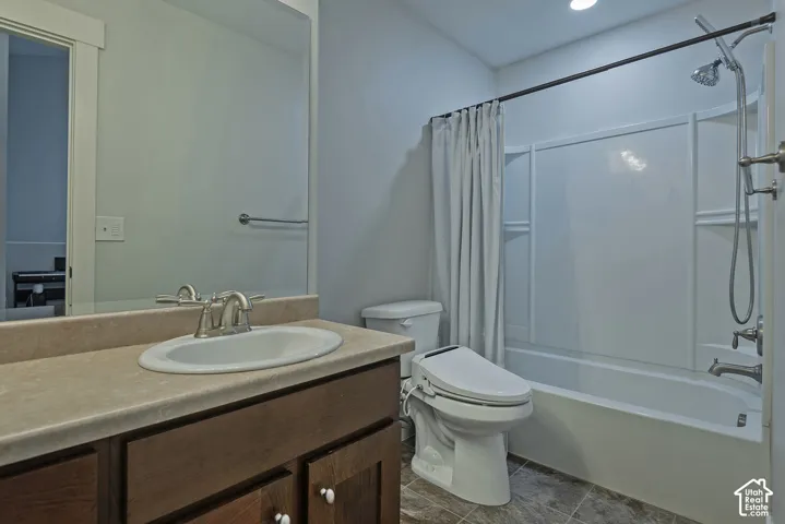 Bathroom featuring a single vanity with dark wood-finish cabinetry, a white oval sink, and a light-toned countertop