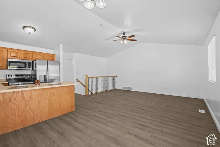 Kitchen featuring wood-finish cabinetry, stainless steel appliances, and a breakfast bar