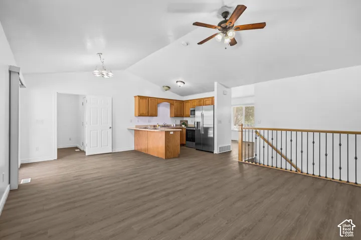 Wood-finish flooring throughout, vaulted ceiling, and recessed lighting