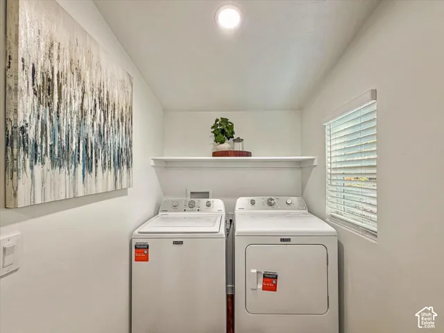 Dedicated laundry area with recessed lighting, white wall shelving, and a window with horizontal blinds