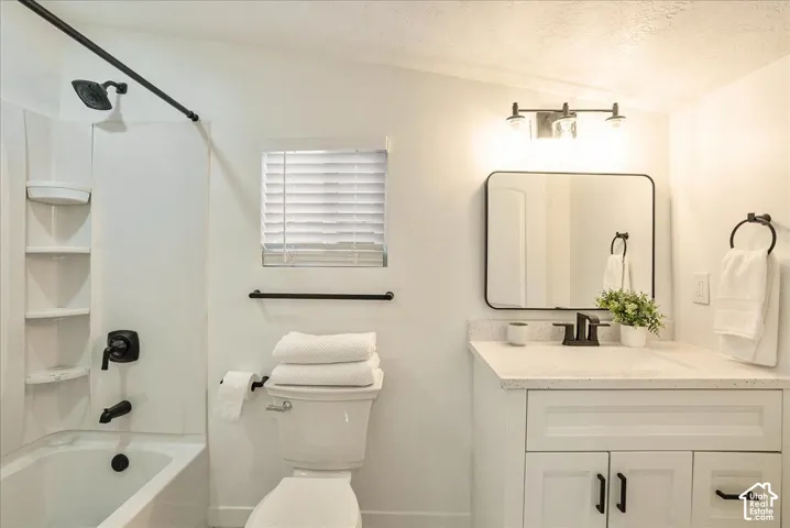White vanity with a light-colored countertop, rectangular mirror, and matte black fixtures