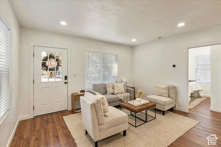 Recessed lighting, wood-finish flooring, white paneled door with windowpanes, and white window blinds