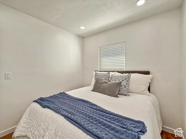 Recessed ceiling lighting, window with horizontal blinds, textured ceiling, and hard-surface flooring