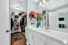 White vanity with an integrated sink, polished chrome faucet, and expansive wall mirror