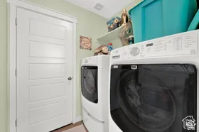 Laundry area featuring a paneled door, wall shelving, and light green wall finish