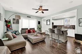 Wood-finish flooring throughout, light-toned wall paint, recessed lighting, and a ceiling fan with integrated lighting