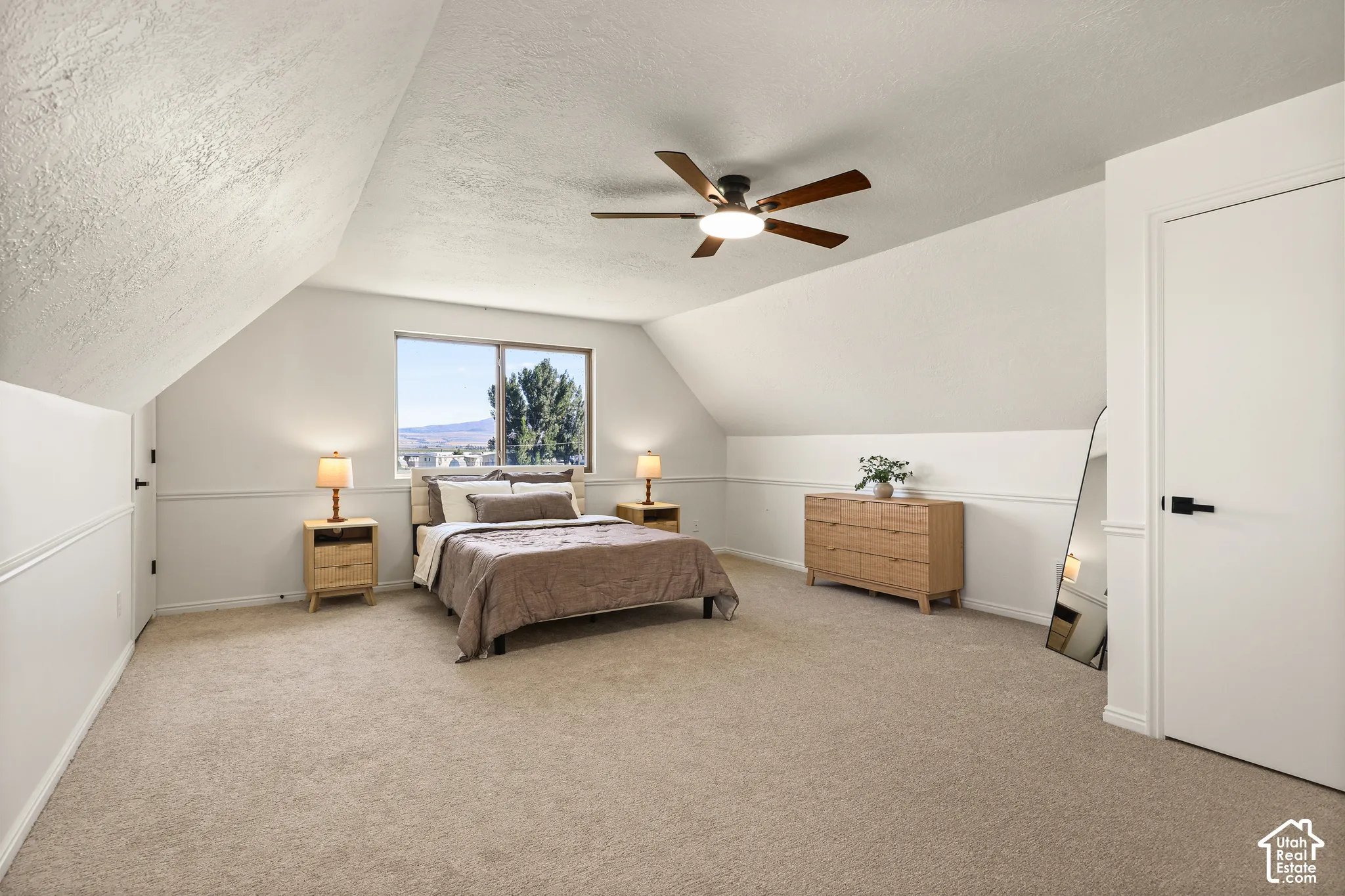 Carpeted bedroom with a window, ceiling fan, and white doors