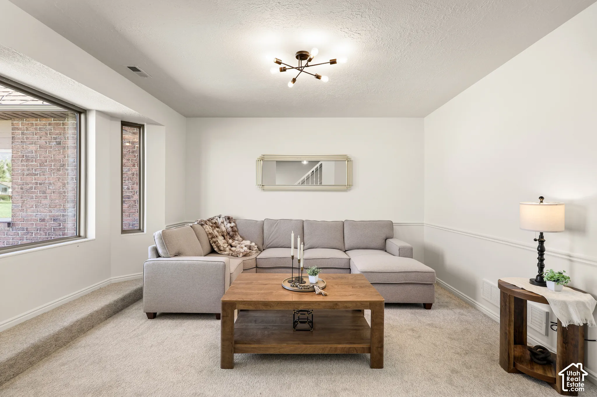 Recessed space featuring neutral carpeting, chair rail molding, and a contemporary ceiling light fixture