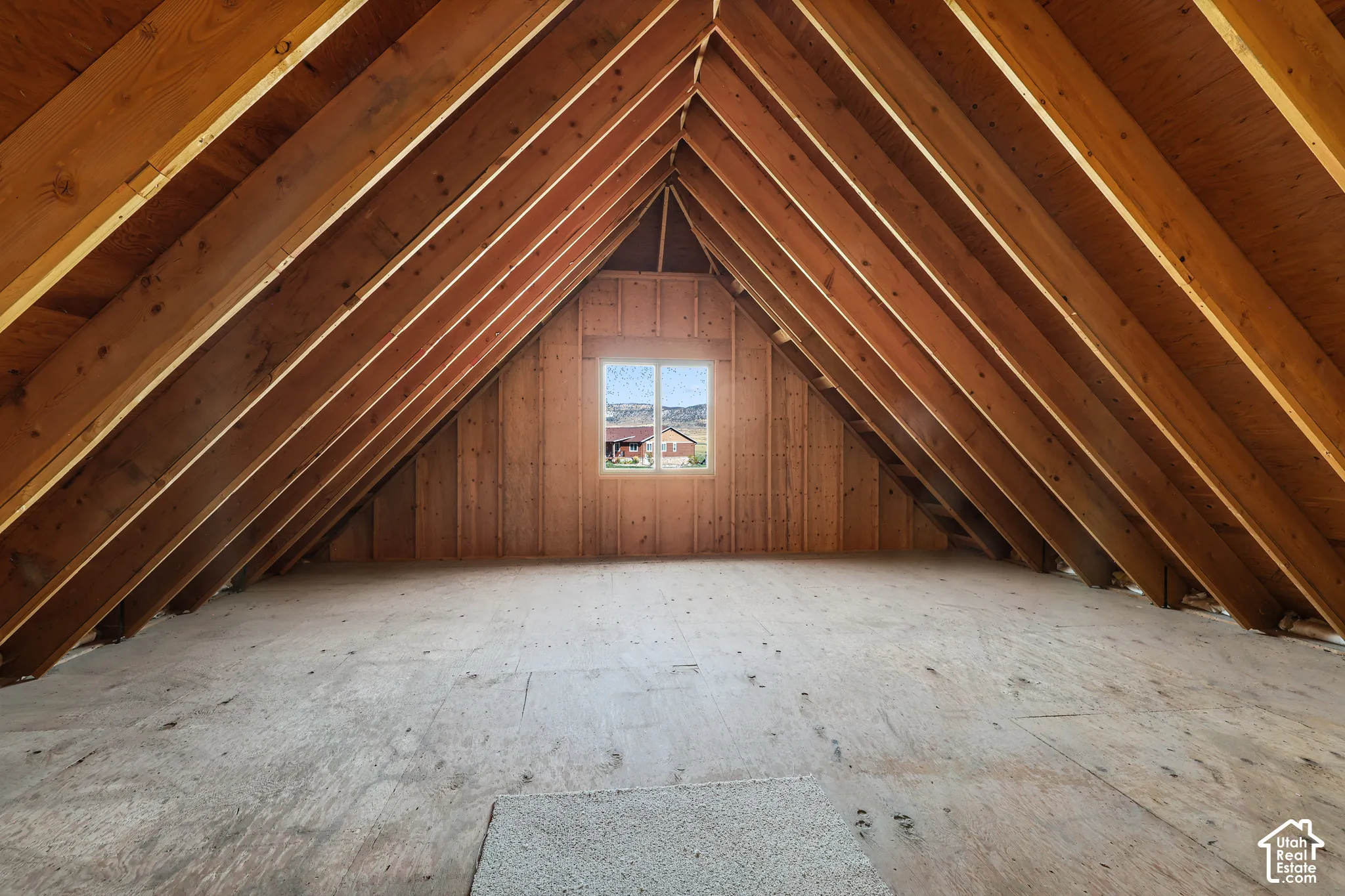 Vaulted wood-beam ceiling, natural wood wall paneling, and a framed window