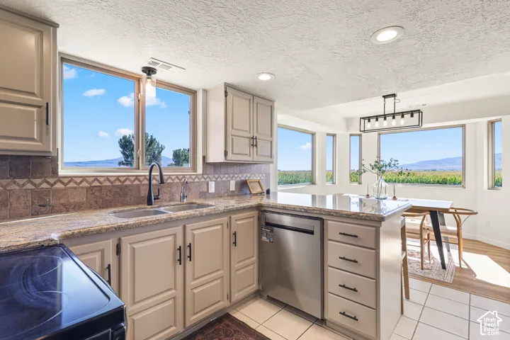 Kitchen featuring granite countertops, tile backsplash, built-in dishwasher, and ample cabinetry