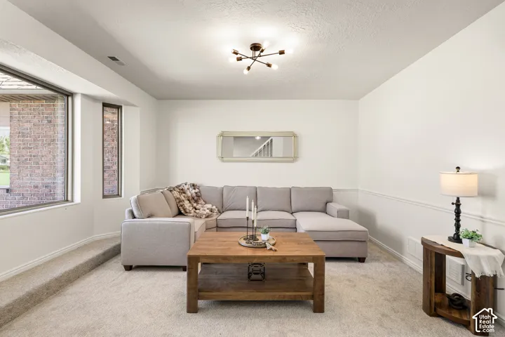 Recessed space featuring neutral carpeting, chair rail molding, and a contemporary ceiling light fixture