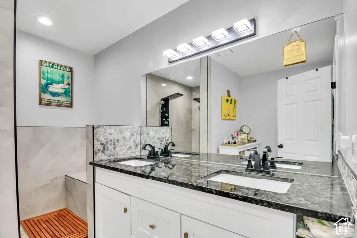 Dual vanity with undermount sinks, stone countertops, and matte black fixtures