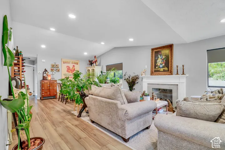 Spacious living area featuring wood-finish flooring, recessed lighting, and a white mantel fireplace
