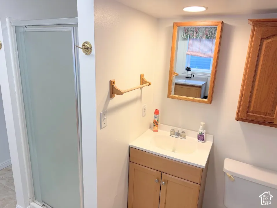 White vanity with integrated sink, chrome faucet, and wood-finish cabinetry