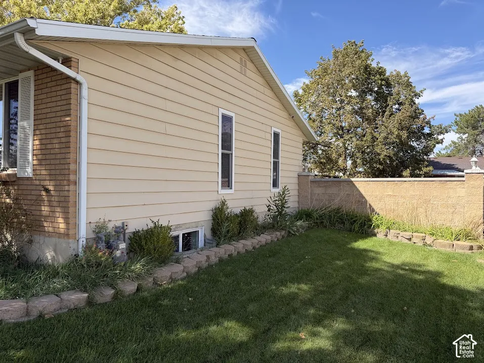 Manicured lawn with a decorative block retaining wall, complemented by a concrete block privacy wall