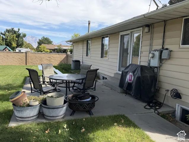 Patio area with concrete surfacing, siding exterior, and a stone privacy wall
