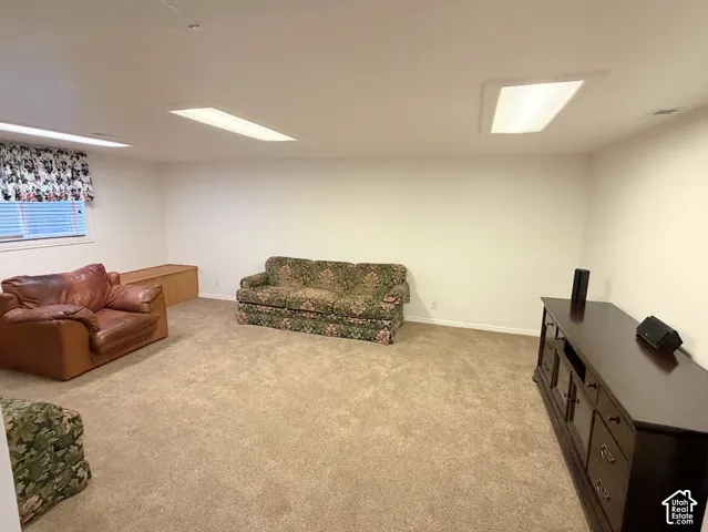 Wall-to-wall carpeting, white walls, and built-in ceiling lighting