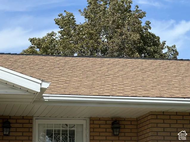 Brown asphalt shingle roofing with white gutters and soffit