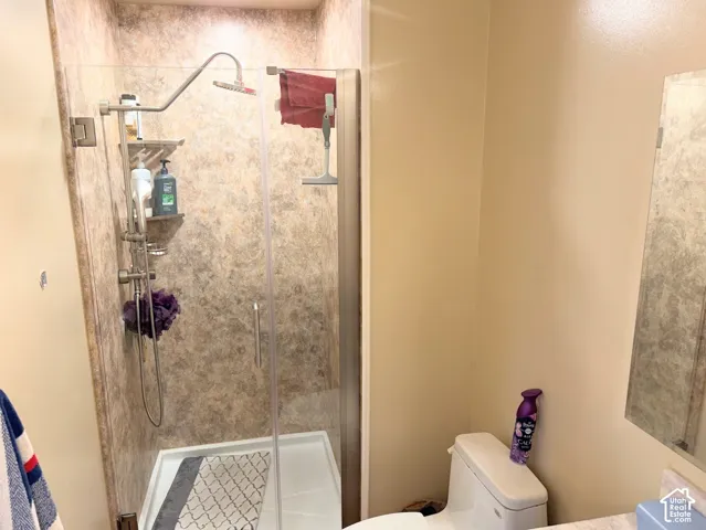 Glass-enclosed shower with a multi-function shower system and patterned surround