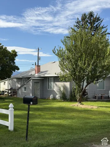 Exterior featuring horizontal siding, a gabled roof, and a red brick chimney