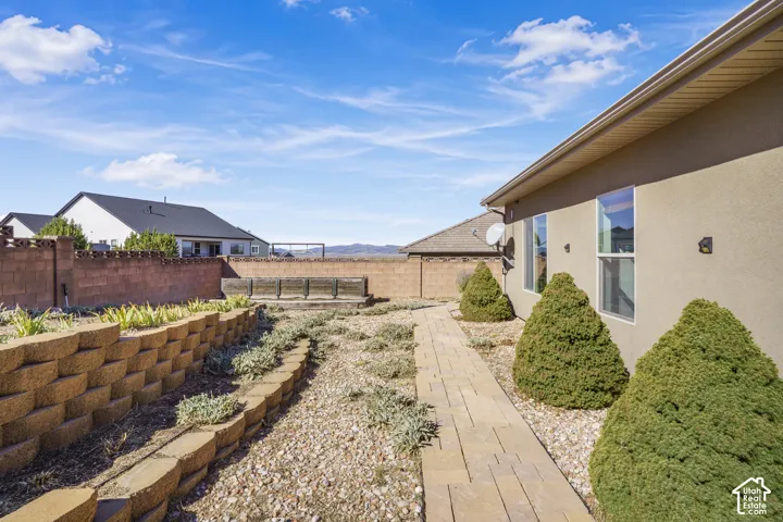 Exterior stucco finish, rectangular windows, and a paved walkway