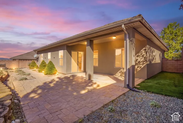 Covered patio with stamped concrete flooring, sliding glass door, and exterior lighting