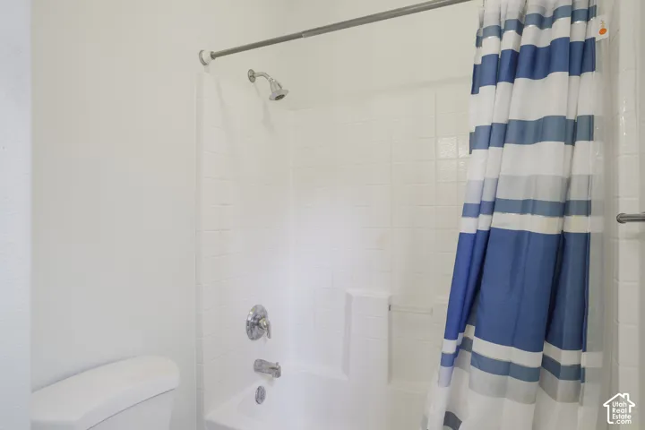 White tiled shower surround with a built-in tub and chrome fixtures