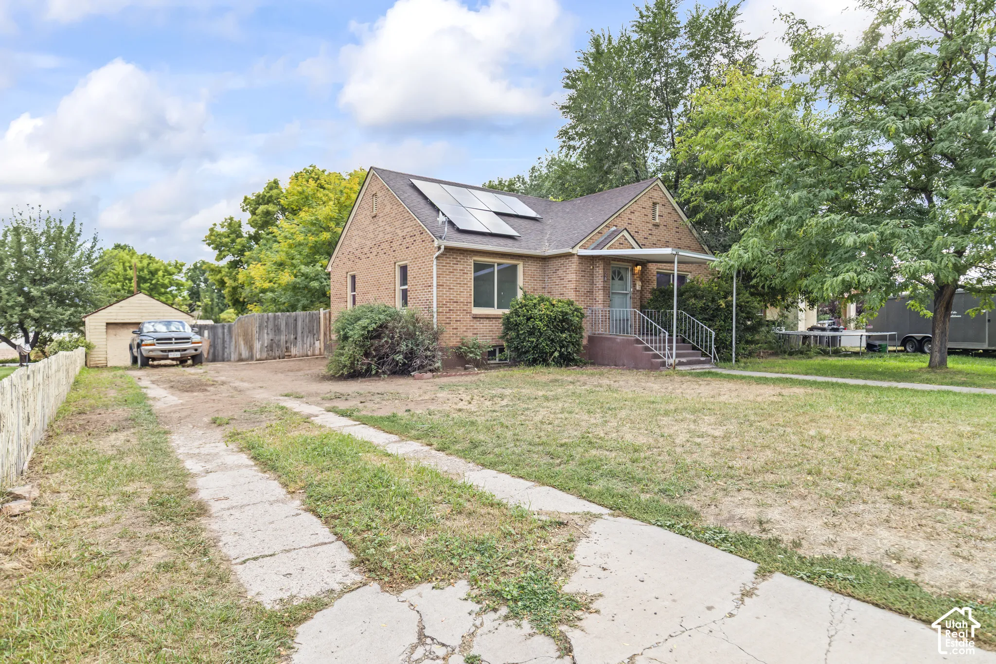 Brick exterior with a covered porch, front entry steps, and a detached garage