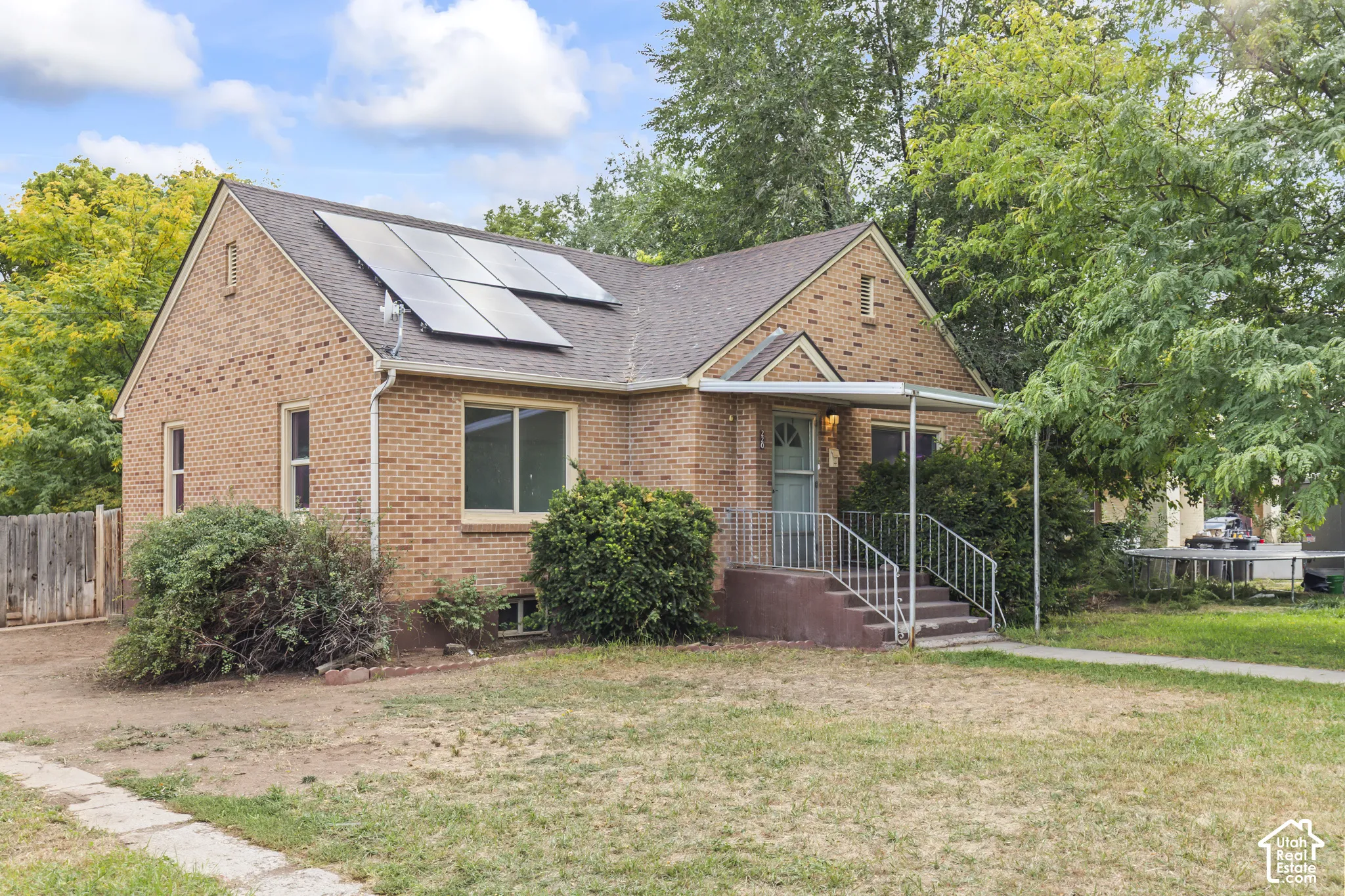 Brick exterior residence with a gabled roof and integrated solar panels