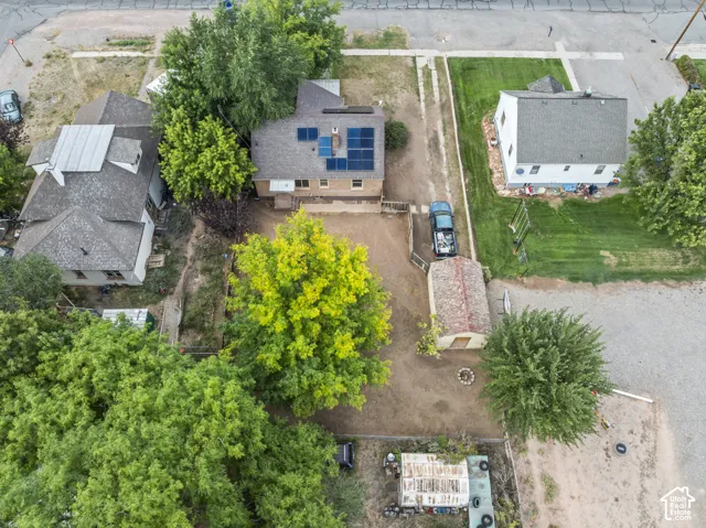 Property featuring solar panels, a detached outbuilding, and mature trees
