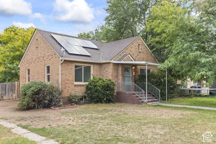 Brick exterior residence with a gabled roof and integrated solar panels