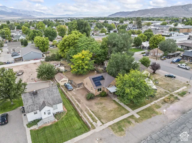 Aerial view showcasing a corner lot with mature landscaping, including established trees and manicured lawn